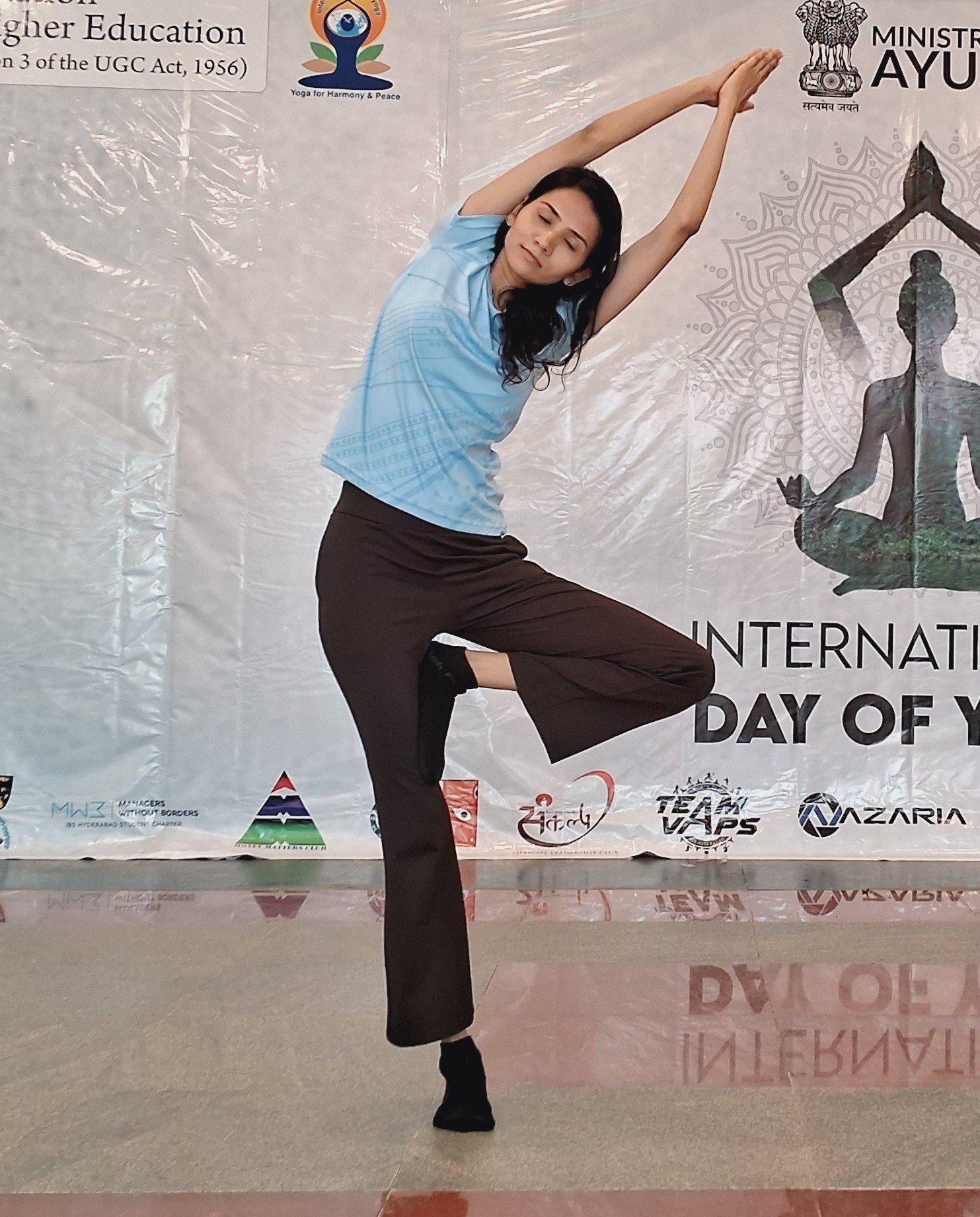 Standing side stretch performed during International Day of Yoga by Asma Fitness