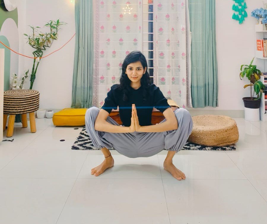 Asma Begum demonstrating a seated yoga posture during a studio session